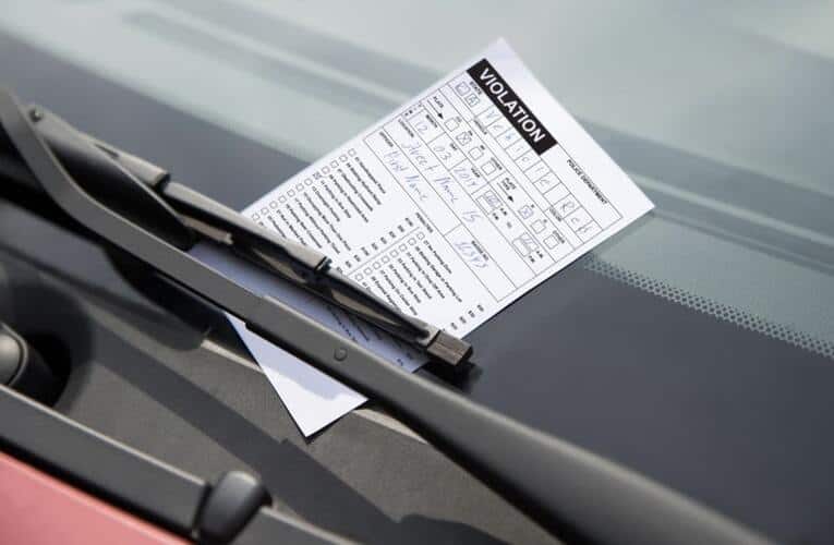 Parking violation under windshield wiper on car window in Baltimore, Maryland